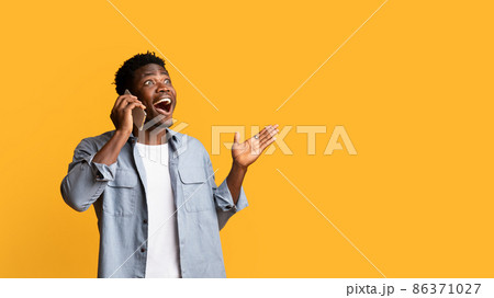 Emotional black man talking on cell phone and gesturing Emotional black man talking on cell phone and gesturing 86371027