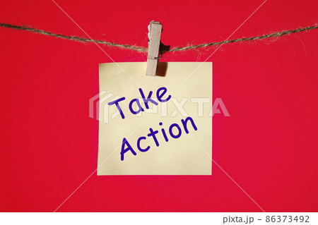 Phrase TAKE ACTION on a yellow sticker on a rope with clothespins on a red background. Business concept. Phrase TAKE ACTION on a yellow sticker on a rope with clothespins on a red background. Business concept. 86373492