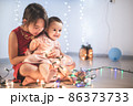 Little sisters having fun at home with chrismass lights. 86373733