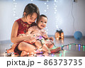 Little sisters having fun at home with chrismass lights. 86373735