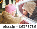 Two little sisters having fun on traditional Christmas market 86373736