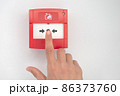 Hand presses fire alarm button 86373760