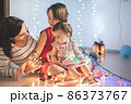Mother with her daughters play with christmass lights 86373767