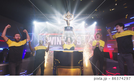 Diverse gamers taking trophy after tournament 86374297