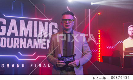 Male announcer showing gaming tournament trophy 86374452