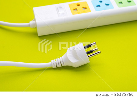Electrical power strip and plug on green background. Top view 86375766