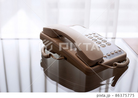 Landline phone on glass table Landline phone on glass table 86375775