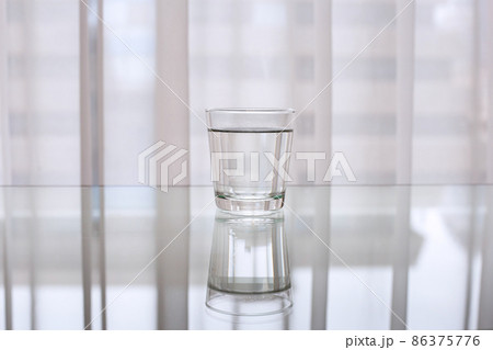 Drinking water in glass on table Drinking water in glass on table 86375776