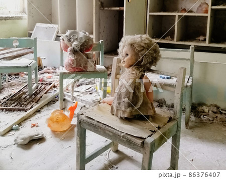 Children's toys covered with dust and debris in the ruins of an abandoned house. Children's toys covered with dust and debris in the ruins of an abandoned house. 86376407