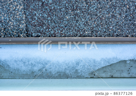 Ice and snow building up inside a rooftop gutter system on a residential house Ice and snow building up inside a rooftop gutter system on a residential house 86377126