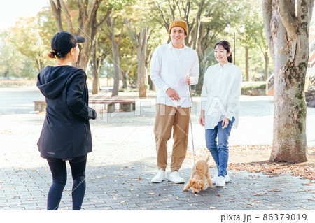犬の散歩中に挨拶する男女 86379019