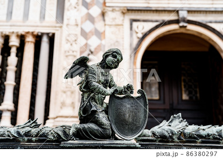 Statue of an angel with a shield near the entrance to the Colleoni Chapel. Bergamo, Italy 86380297