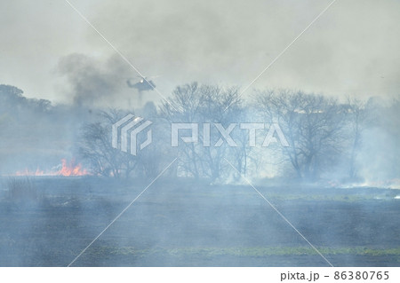 渡良瀬遊水地で起きた野火に消火するヘリコプター 86380765