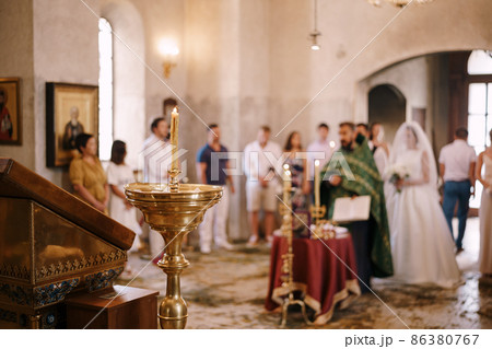 Lighted candles on stands in the church during the wedding ceremony Lighted candles on stands in the church during the wedding ceremony 86380767