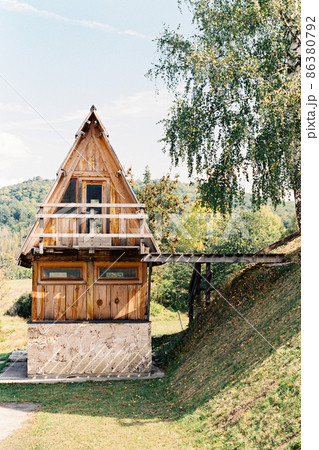 Triangular two-story house with a wooden bridge to the hill 86380792