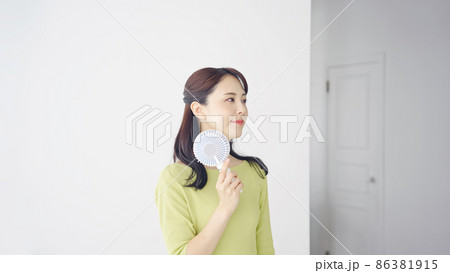 ハンディファンを使う女性　ポータブル扇風機 86381915