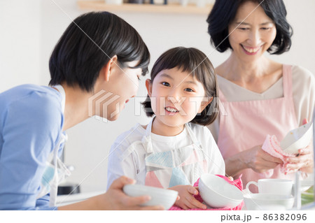 三世代ファミリー　ママとおばあちゃんと食器を拭く女の子　 86382096