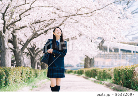 桜並木の通りを通学する女子高生 86382097