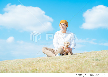 犬の散歩をする男性（座る） 86384026