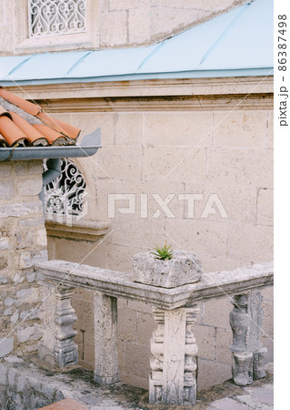 Stone balustrade near the wall of an ancient building. Close-up Stone balustrade near the wall of an ancient building. Close-up 86387498