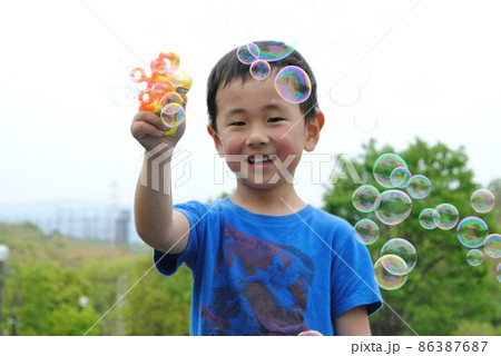 シャボン玉を作って楽しむ男の子 86387687
