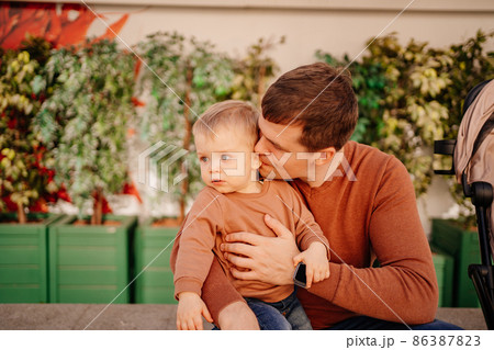 dad kisses and hugs with his son. games and walks with children.  86387823