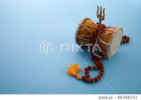 Shivaratri background with Shivas trident and Pellet Drum Damroo musical instrument . Hindu festival Maha Shivratri 86388231