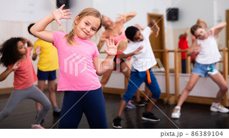Girl exercising in group during dance class Girl exercising in group during dance class 86389104
