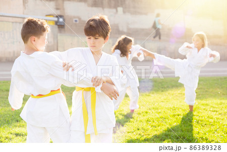 Children exercising karate moves 86389328