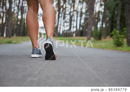 Young woman running outdoors in a city park Young woman running outdoors in a city park 86389779