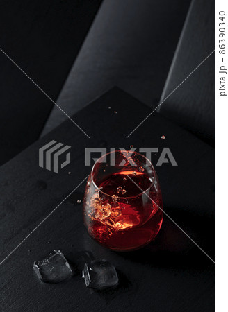 Ice cubes fall into a glass of whiskey. Ice cubes fall into a glass of whiskey. 86390340