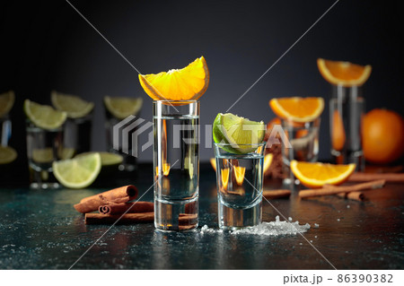 Tequila shots on a black background. Tequila shots on a black background. 86390382