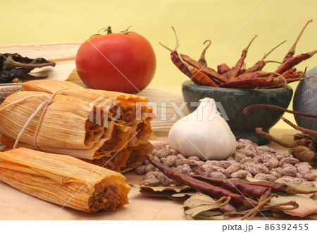 Tamales With Garlic, Beans and Tomato on Yellow Background 86392455