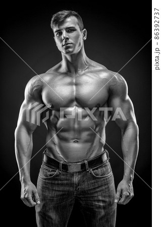 Muscular bodybuilder guy doing posing over black background Muscular bodybuilder guy doing posing over black background 86392737