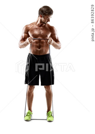 Handsome fitness man working out with rubber band, studio shot. Handsome fitness man working out with rubber band, studio shot. 86392829