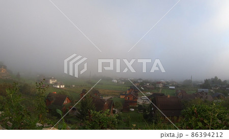 Morning fog dissipates in the mountains Carpathians. 86394212