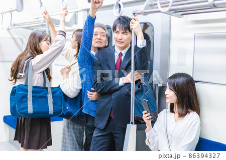 満員電車に乗る乗客たち 86394327