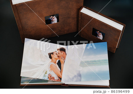 wedding photobooks in brown leather binding with photos on the cover 86396499