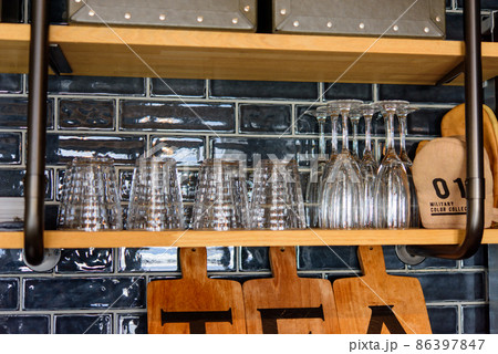 おしゃれなキッチンの吊棚に収納されたグラス類 86397847
