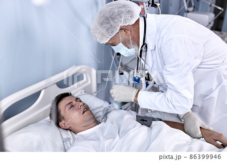 Experienced Male Doctor Check the Pulse and the Patient's Health Condition Lying On Bed Experienced Male Doctor Check the Pulse and the Patient's Health Condition Lying On Bed 86399946