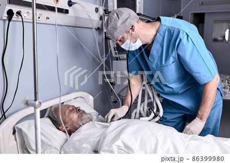 confident male doctor putting stethoscope to senior patient, checking the heartbeat. confident male doctor putting stethoscope to senior patient, checking the heartbeat. 86399980