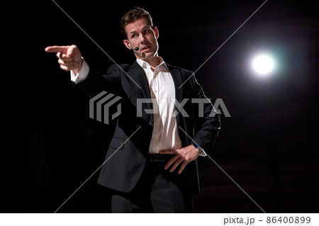 Business coach standing on stage and pointing finger to camera. Confident Caucasian speaker Business coach standing on stage and pointing finger to camera. Confident Caucasian speaker 86400899