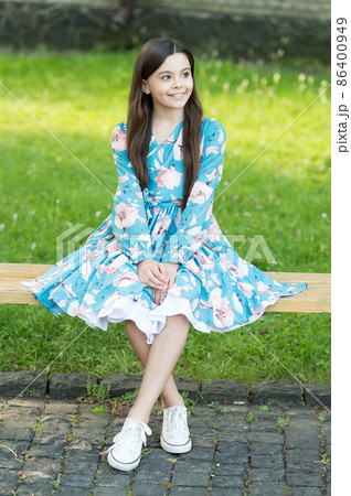 Little girl with long hair relaxing in park sunny day green grass 86400949