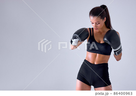 Defence. Young fit woman athletic female MMA fighter training isolated in studio Defence. Young fit woman athletic female MMA fighter training isolated in studio 86400963