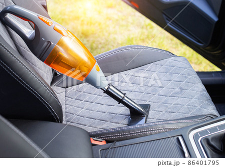 Cleaning a modern car interior with a vacuum cleaner from dirt and dust, background. Equipment 86401795