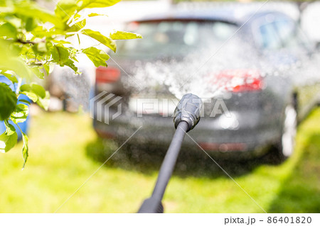 Car wash with modern car shampoo using a high pressure washer in summer. Background, cleaning cars from dirt 86401820