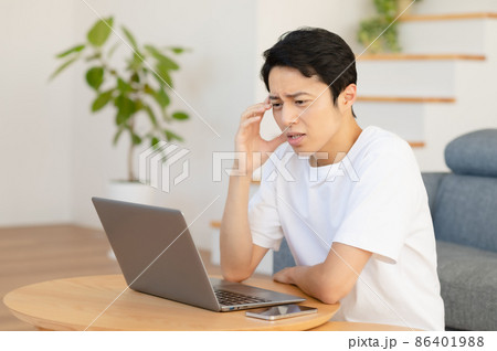 自宅でテレワークする若い男性(困る、悩む、ネガティブ) 自宅でテレワークする若い男性(困る、悩む、ネガティブ) 86401988