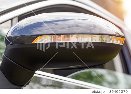 Orange LED turn signal in the mirror of a modern car, close-up 86402070