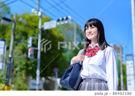 横断歩道を渡る、歩きで学校から登下校する女子高校生　通学登校　上半身　住宅地　市街地　 86402190