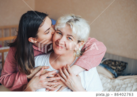 Young daughter of mature beautiful blonde mother kissing 86402763